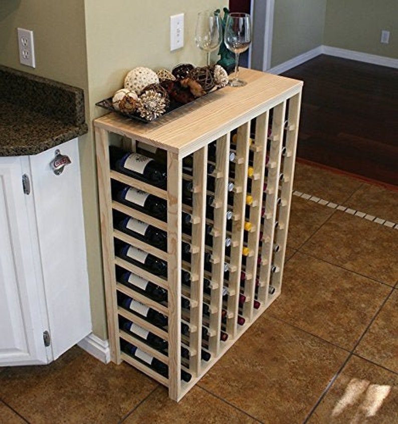 A wine rack with many bottles of wine on top