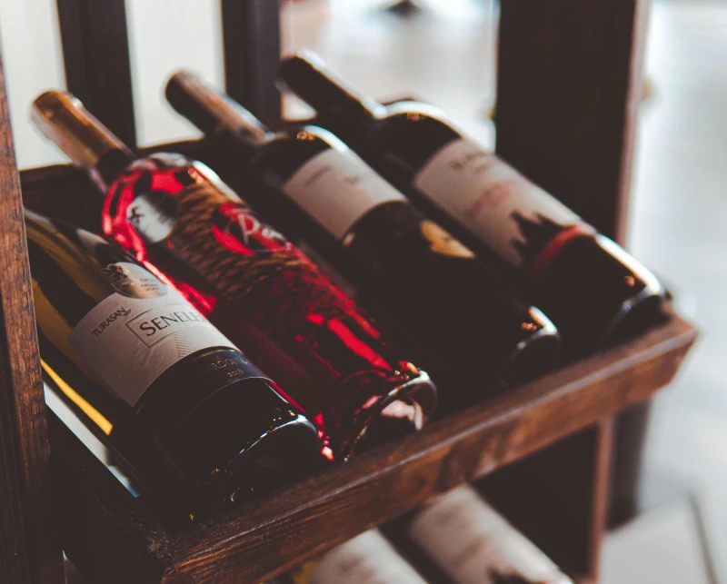 A wooden rack holding several bottles of wine.